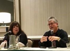 Man and woman at table presenting a PowerPoint